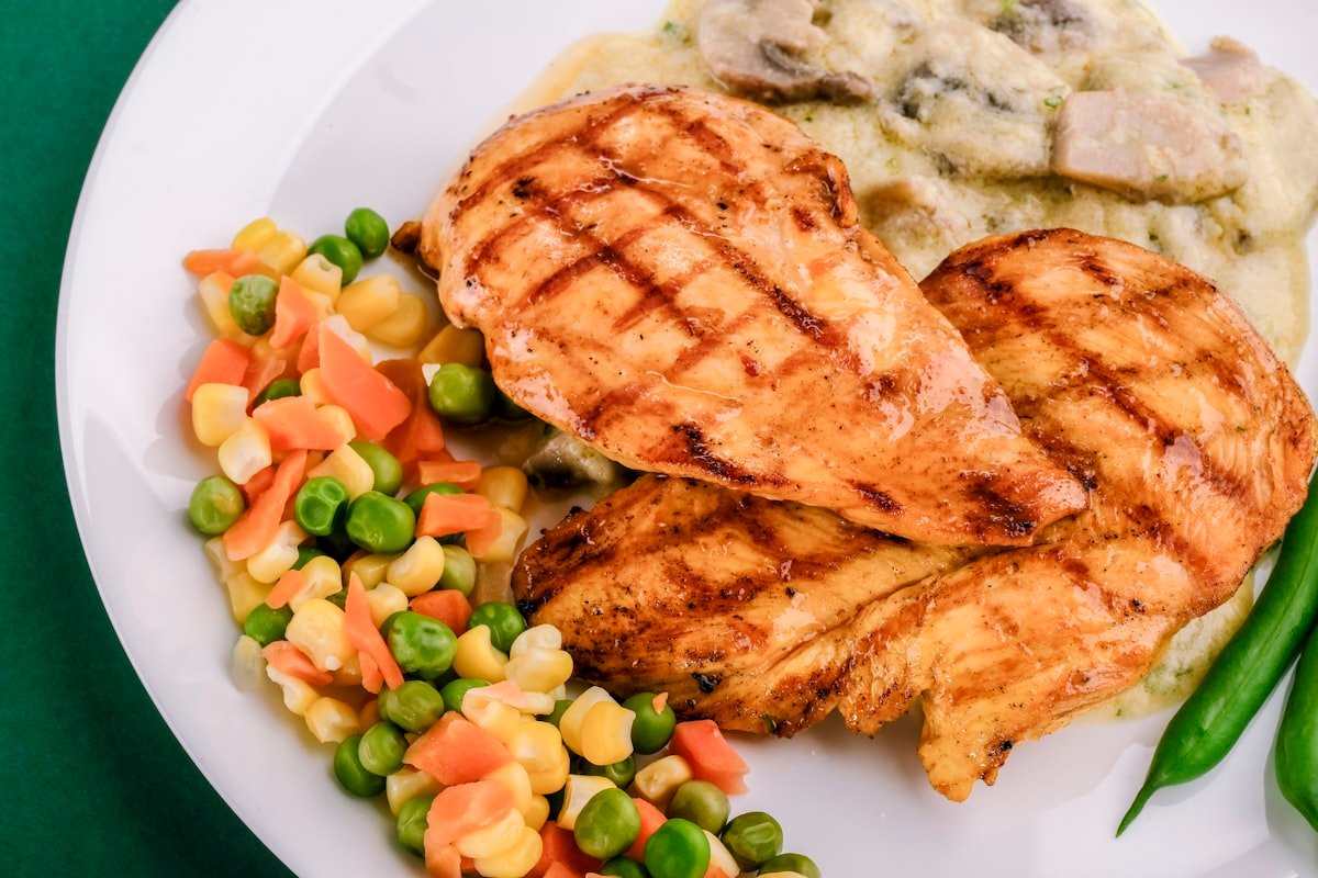 Pan-seared lean chicken breast with sweet potatoes and green vegetables